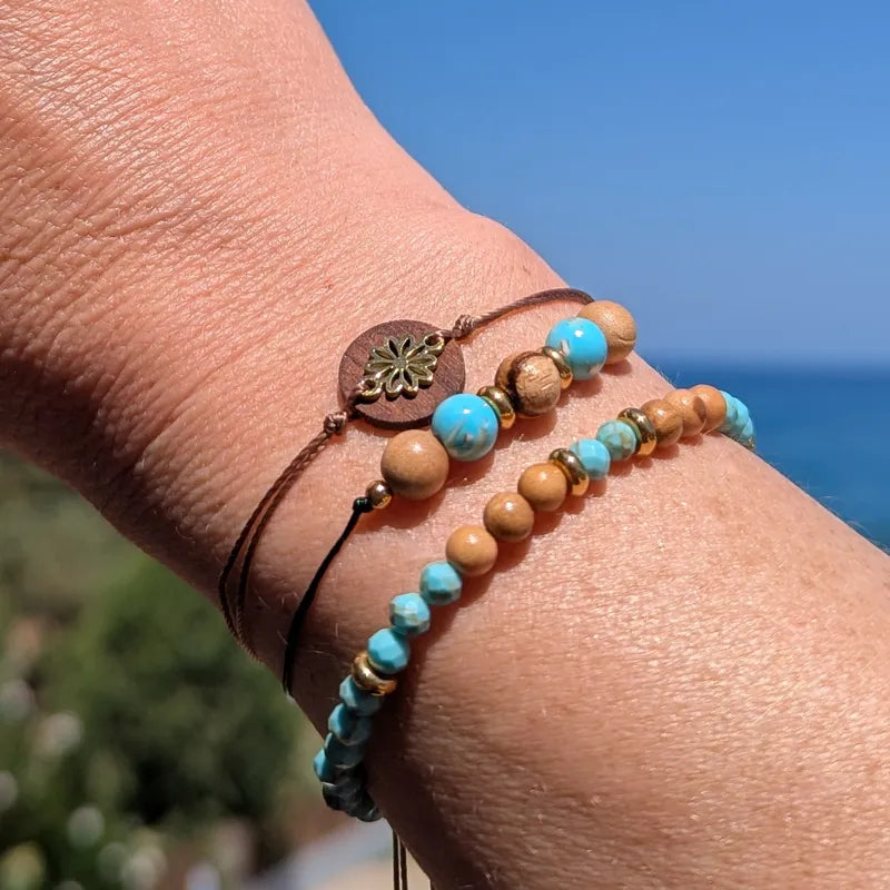 Drei Holzarmbänder an der Hand