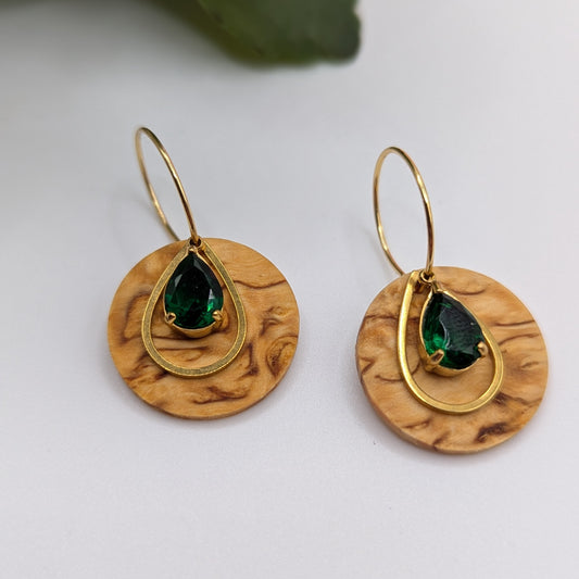 Runde Holzohrringe auf Creolen mit einem grünen Stein